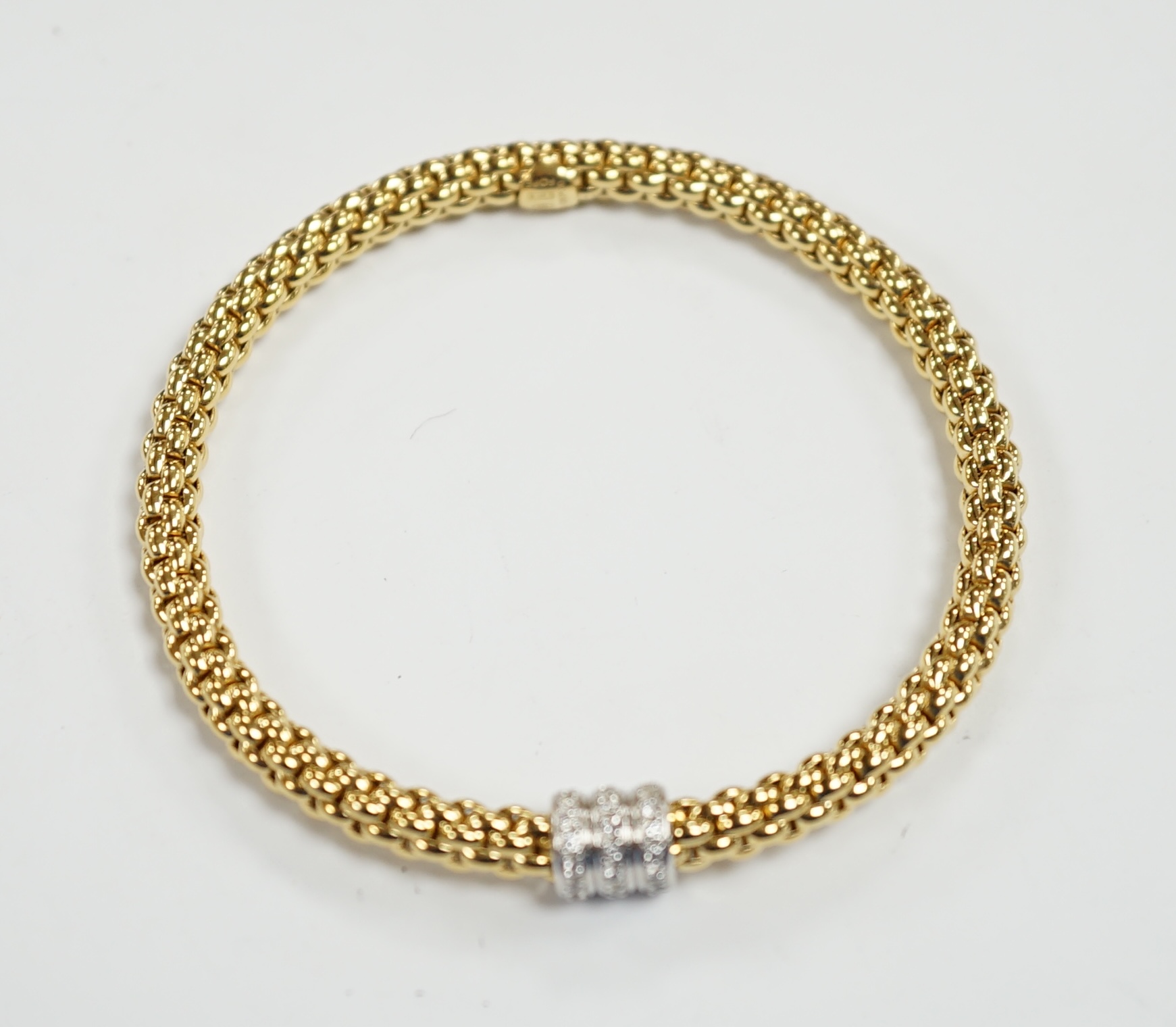 An Italian 18kt Fope flexible bracelet, with diamond chip set barrel shaped motif, gross weight 17.1 grams, with Fope box.
